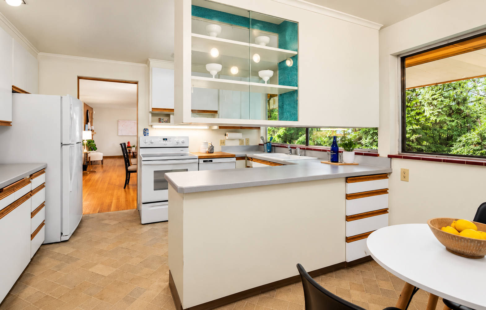Kitchen before remodeling with white cabinets and grey countertops